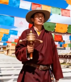 藏族男子寺庙前手持转经筒11768#横屏 