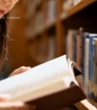  女孩在书架前专注阅读书籍4517#竖屏 	 