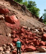 工人查看道路旁山体落石5007#横