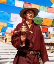 藏族男子寺庙前手持转经筒11768#横屏 