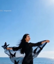  女子在海滩展开带蝴蝶装饰的纱巾2521#竖屏 	 